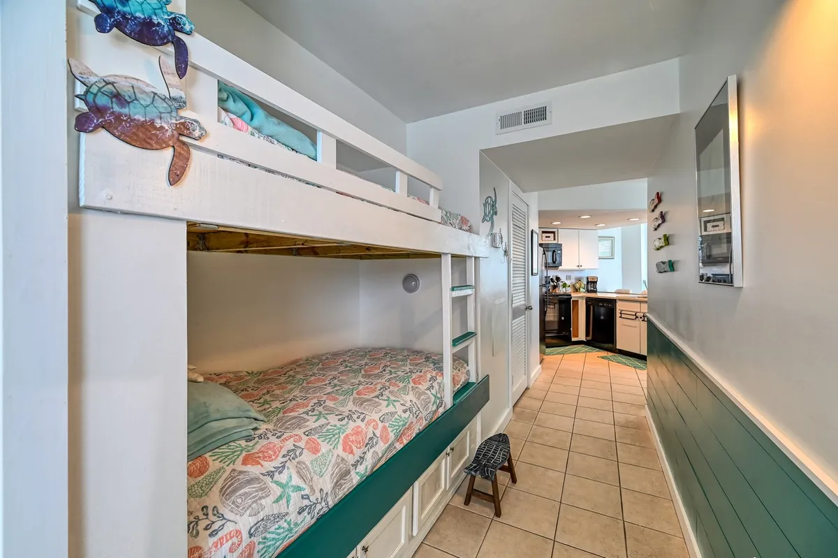 A playful alcove featuring a built-in bunk bed with colorful bedding and whimsical turtle decorations. The space feels cozy and inviting—ideal for children to read, play, and sleep comfortably.